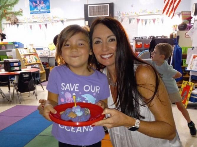Penni Stoudenmire smiles in her classroom with one of her Kindergarten students after an in-class activity. Stoudenmire uses hands-on activities like this one to foster an enjoyable and engaging environment for her students. (Submitted Photo)