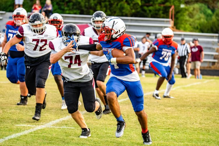 OCHS running back Elijah Hood delivers a stiff arm to a Chestatee defender while running down the field for a big gain. Hood is slated to start as running back for the Patriots in August. (Photo/Jack Casey)