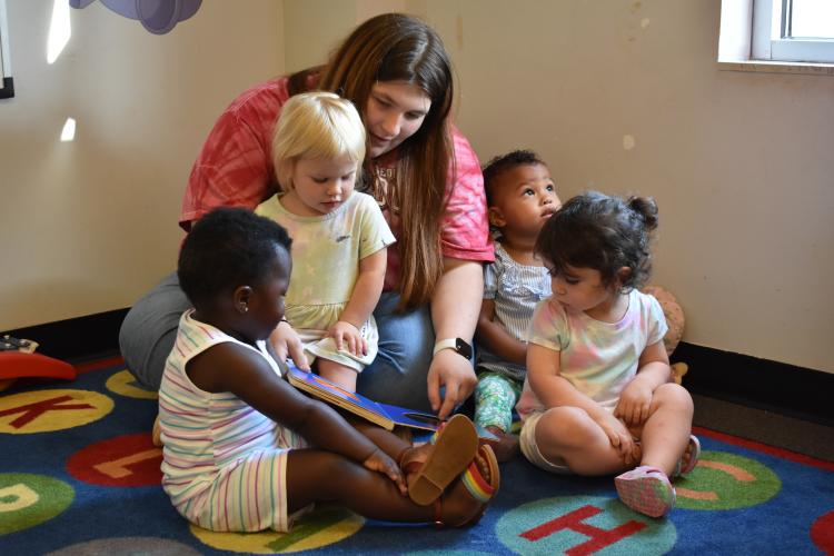 Brandy Epps huddles children in the 1-year-old class for circle time. These times include storytelling, identifying colors and singing songs. (Photo/Sarah Evans)