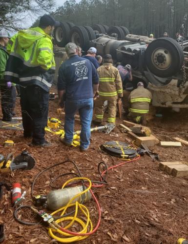 First-responders aid the driver in the wreckage on January 25. He was trapped inside the cab of the vehicle and had to be cut out. (Submitted photo/Jay Paul)