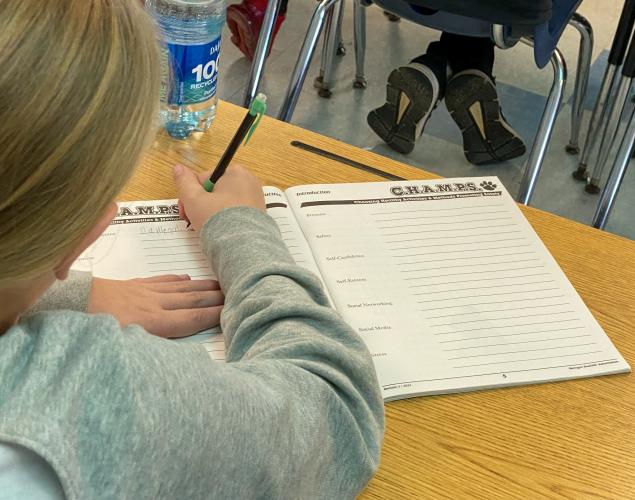 A student writes the definition of methamphetamine from a PowerPoint presentation during the C.H.A.M.P.S. program at Oglethorpe County Elementary. (Brooke Stewart/Photo)